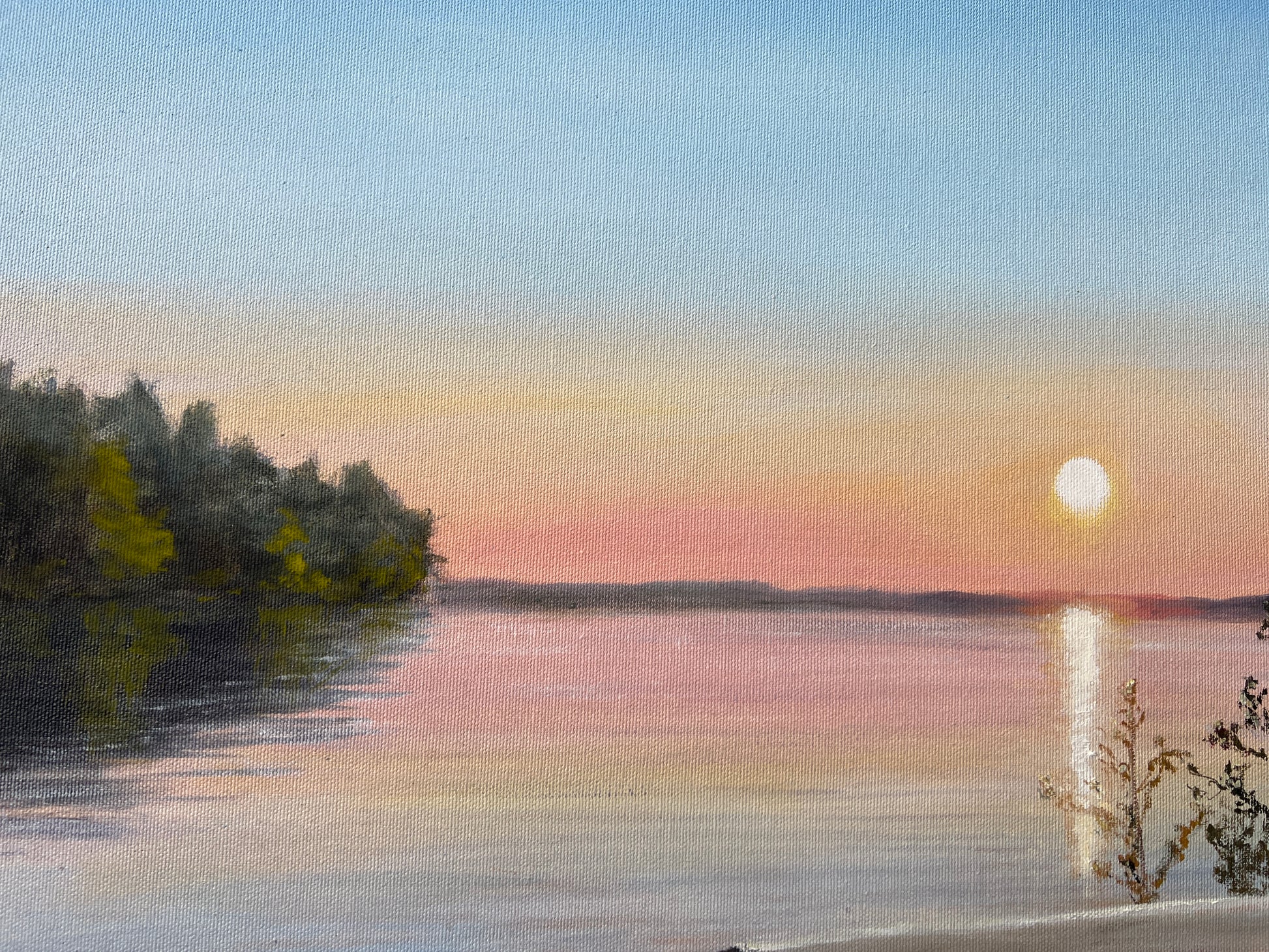 Sunset over a lake with trees on the shore