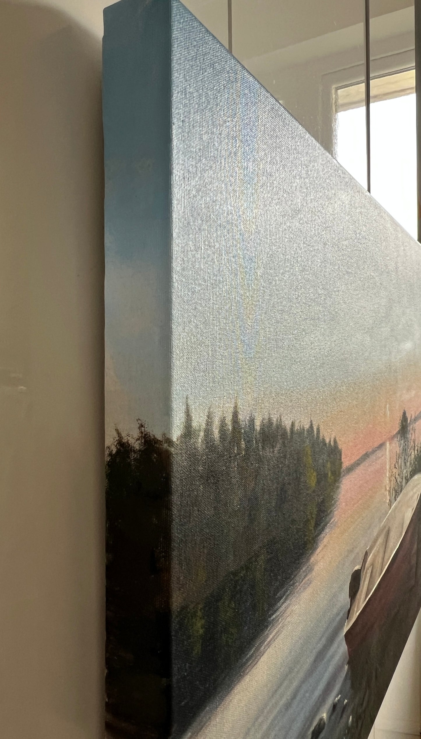 Unframed painting of a landscape with trees and water.