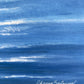 A close-up of a blue painted canvas or textured print with horizontal brushstrokes and a white script signature near the lower right reading 'Oksana Salminen'.