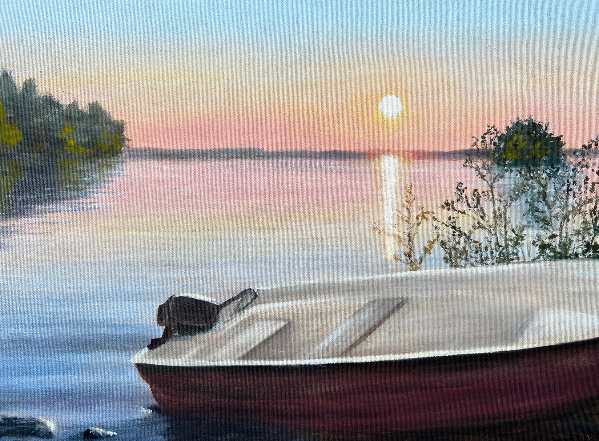 Boat on a lake at sunset with trees and calm water
