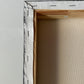 Close-up of a wooden picture frame with a gray interior.
