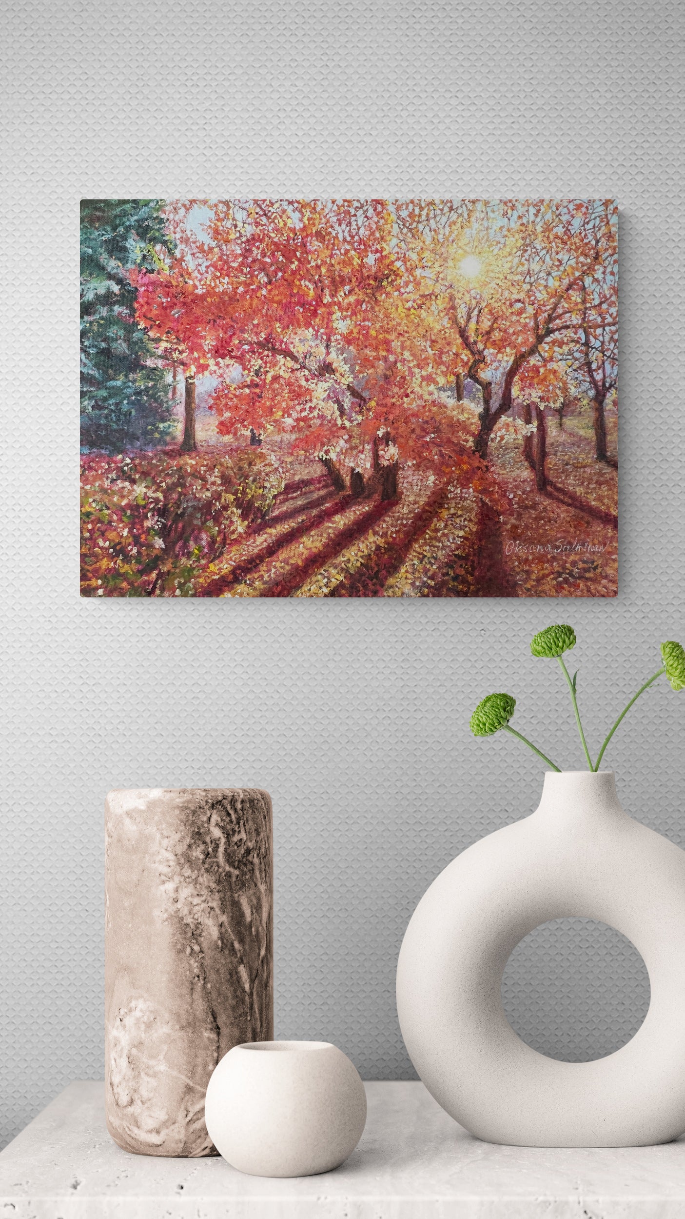 Oil painting of a colorful autumn landscape with trees and a path, displayed on a wall above decorative vases.
