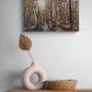 Canvas print of a forest scene above a wooden shelf with a vase and basket.