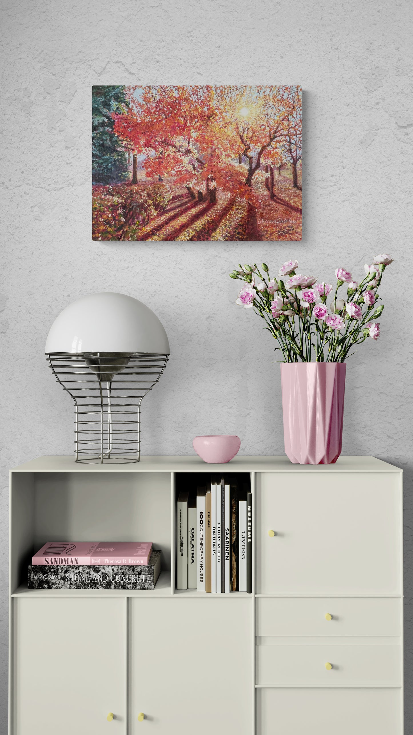 Decorative shelf with books, a vase of flowers, and a painting on a gray wall.