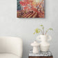 Autumn-themed wall art above a side table with decorative vases.