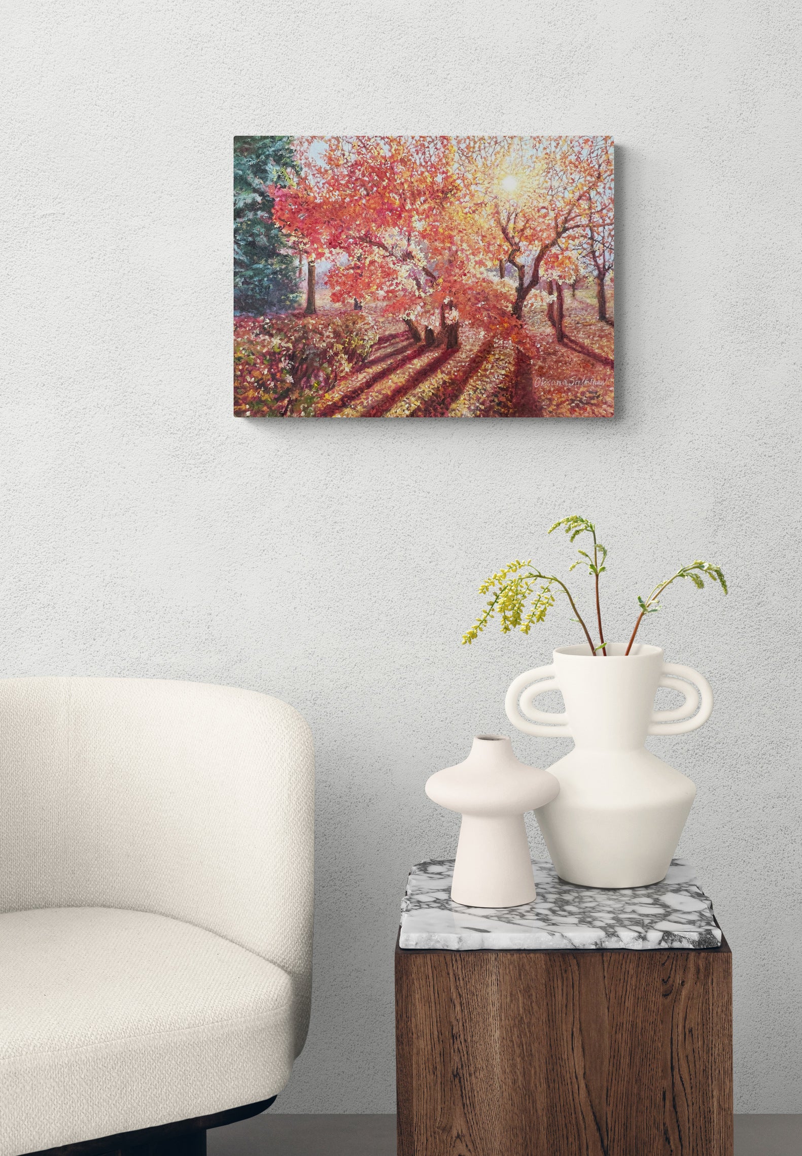Autumn-themed wall art above a side table with decorative vases.