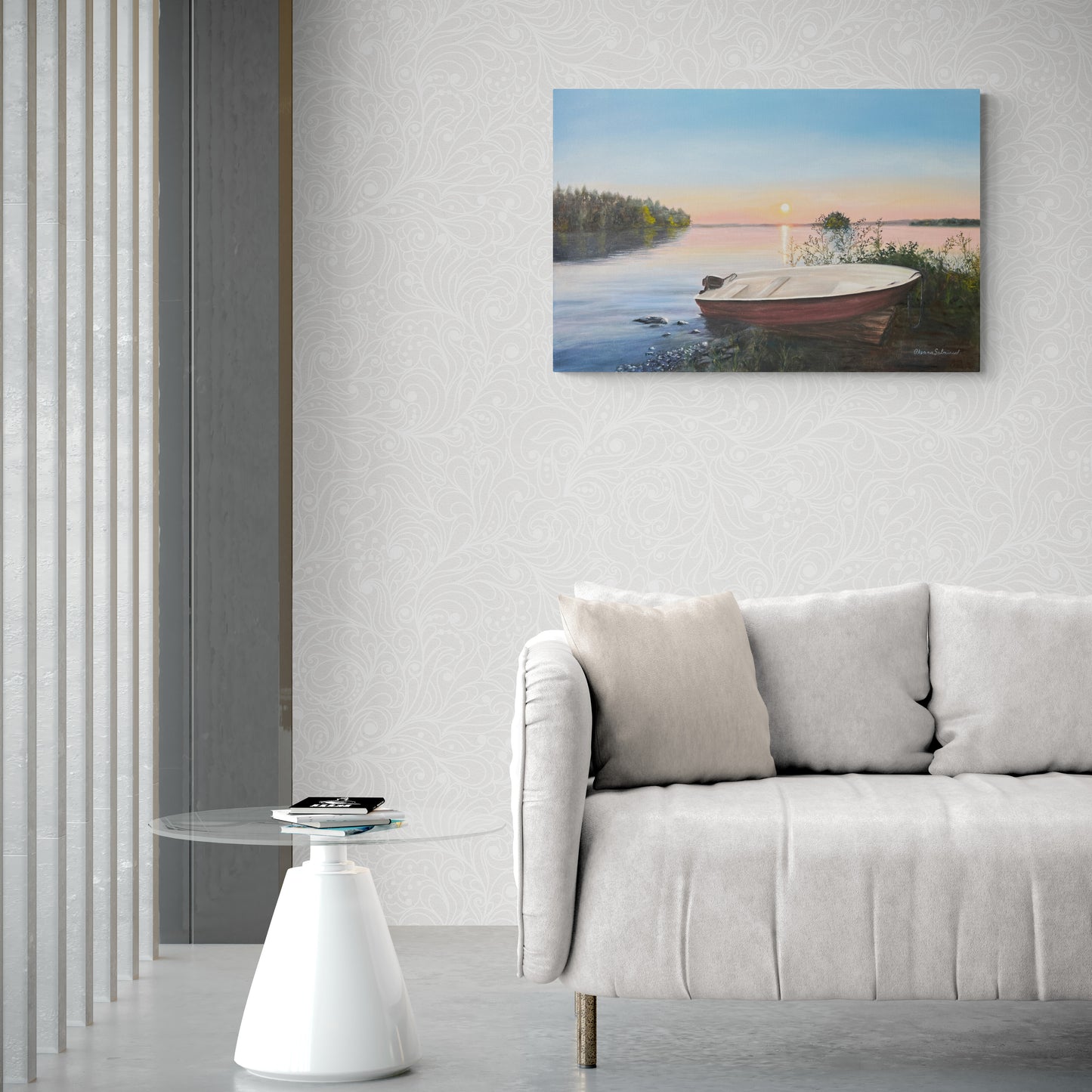 Painting of a boat on a lake hanging above a sofa in a living room.