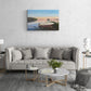 Living room with a gray sofa, marble coffee table, and wall art of a boat on water.