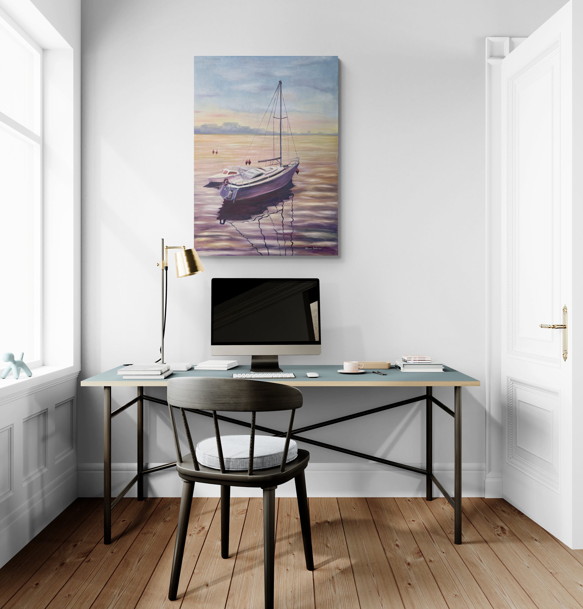 Modern home office with a desk, chair, and wall art of a boat.
