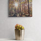 Canvas print of a forest scene with a potted plant on a white surface.